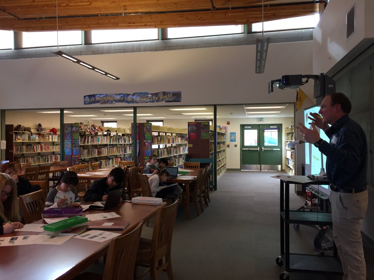 Adult in front of students teaching.