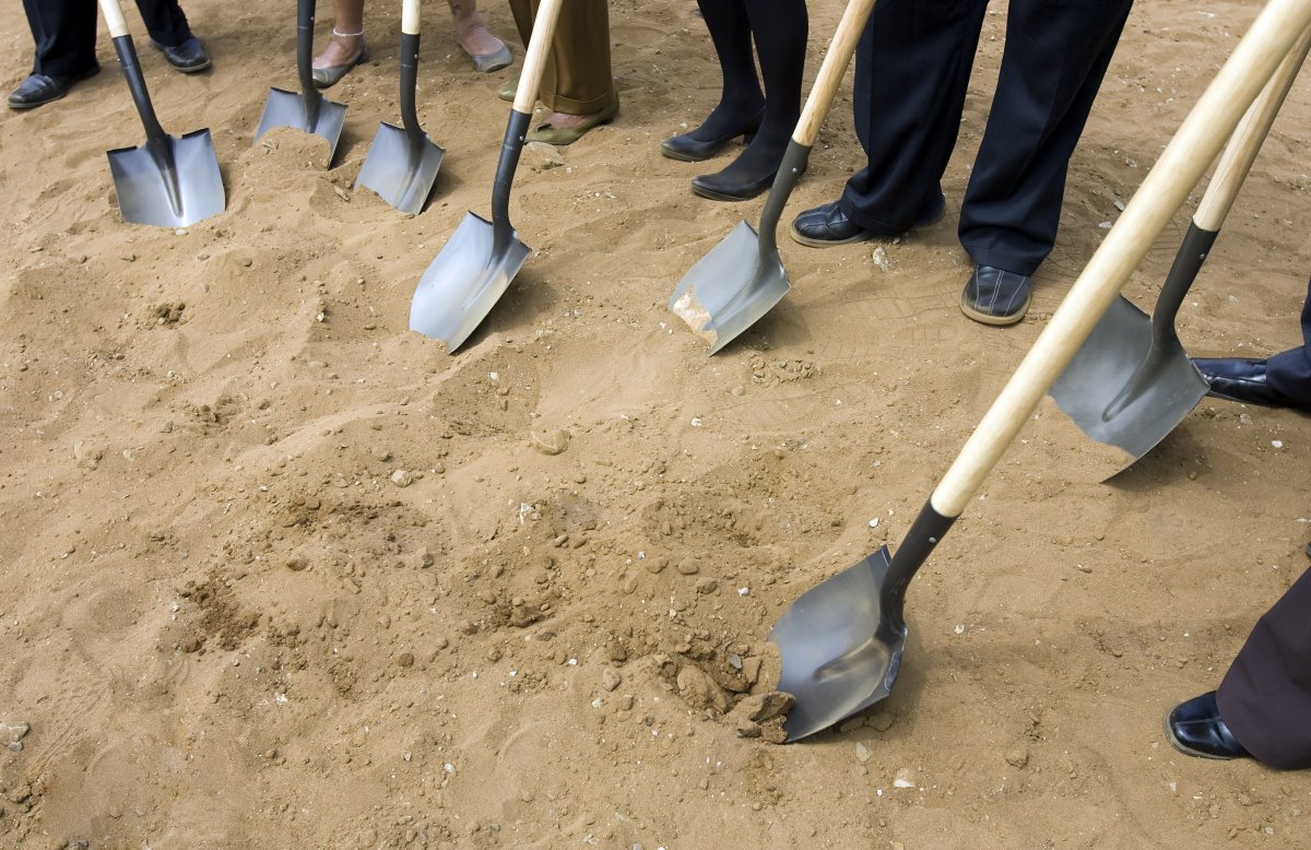 a group of people holding shovels about to break ground 