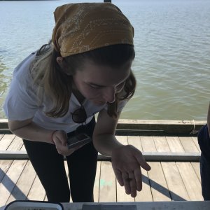 June wearing a bandana and holding a small crab