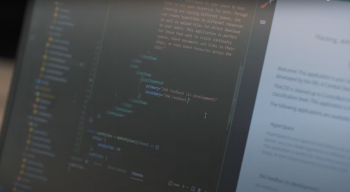 A close up view of a computer screen that is black with orange and green coding text.