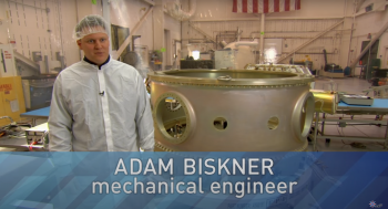 Man in a white coat in front of a large round piece of meatal with text saying Adam Biskner mechanical engineer