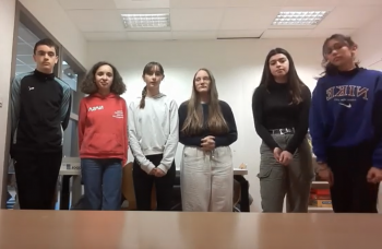 A group of 5 middle school girls and 1 middle school boy looking at the camera