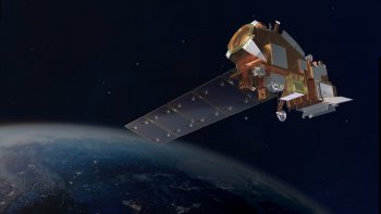 A silver and orange satellite orbiting Earth