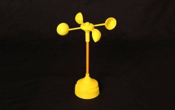Image of a yellow 3D printed anemometer with a base, a pencil as a vertical component and four half spheres on a horizonal top piece