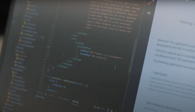 A close up view of a computer screen that is black with orange and green coding text.