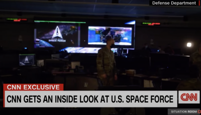 A screen shot of a CNN video with of a command rom with mand standing in the center, two screens behind him, and a title at the bottom that say inside look at U.S. space force. 