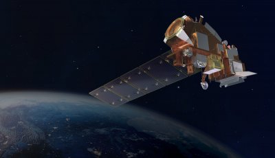 A silver and orange satellite orbiting Earth