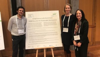 Professor Martin Bascopé, Dr. Janna Pahnke, and Dr. Carol O'Donnell stand in front of a poster highlighting their paper, "Using Science to Do Social Good: STEM Education for Sustainable Development"