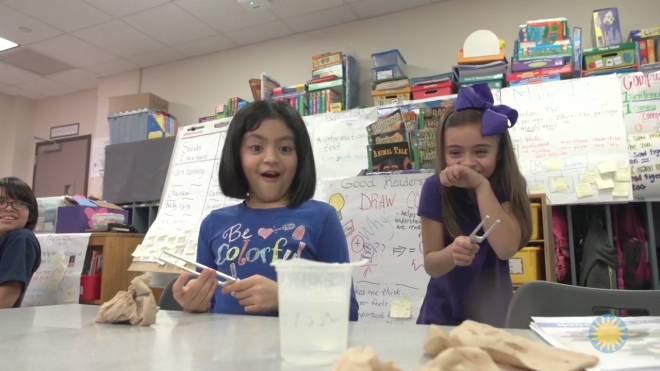 Image of students interacting with a tuning fork during a science experiment